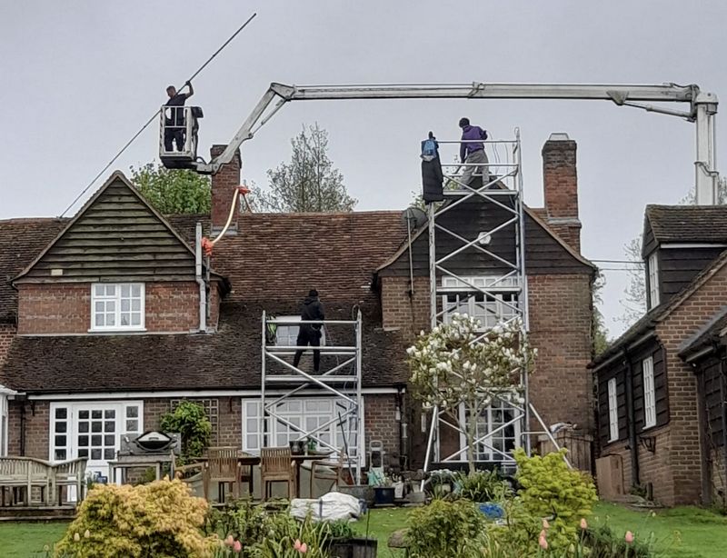 The Roof Moss Cleaners using cherry picker and scaffolding to clean roof safely and professionally in Liphook, Hampshire